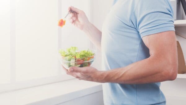 man has healthy lunch, eating diet vegetable salad