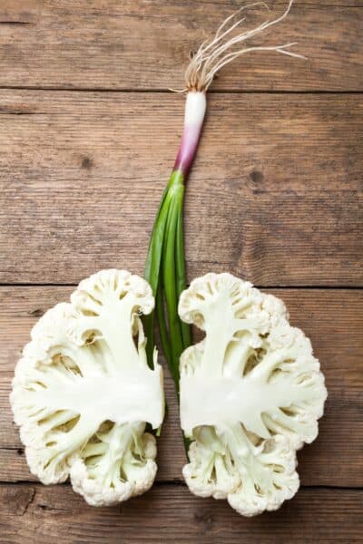 cauliflower split into half with green onions imitating lungs and windpipe