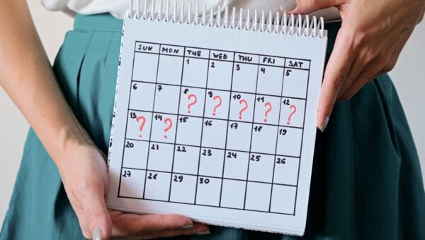 Woman holding calender with marked missed period