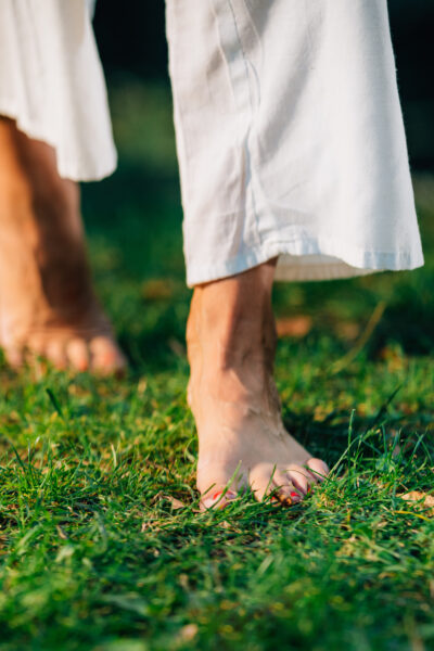 slender bare feet walking on grass