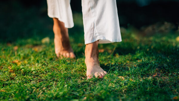 slender bare feet walking on grass