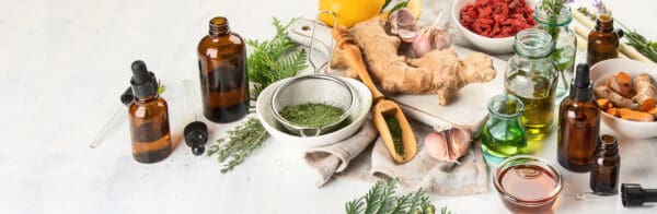arrangement of herbs, oils, ginger, lemons, etc on a white background